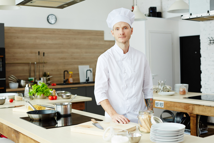 Il cuoco prepara il cibo cucinare con pentole grandi e un mestolo  lavoratore di cucina con un mestolo chef professionista